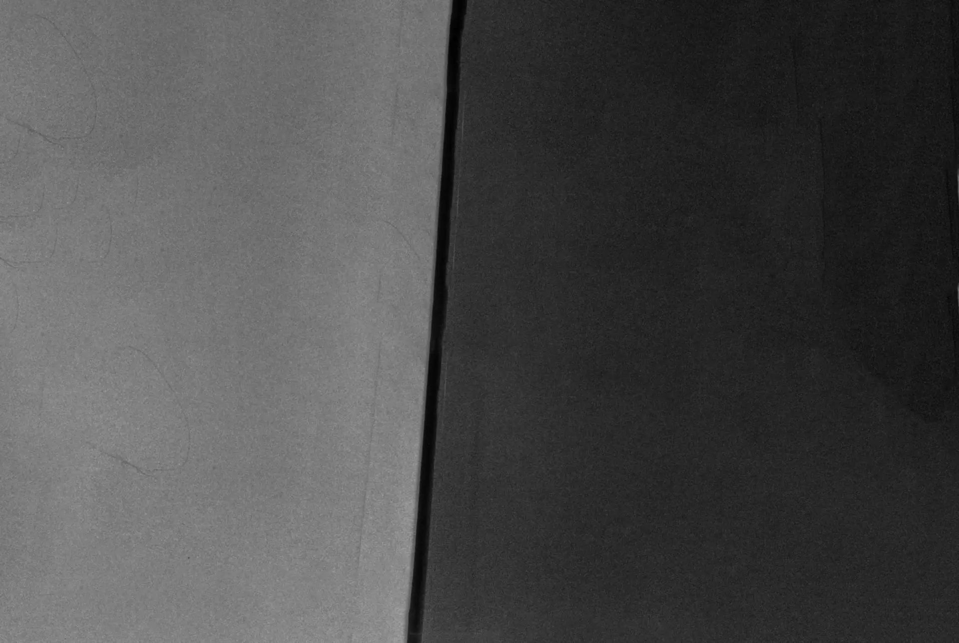 Cette photographie en noir et blanc, prise en décembre 1999, capture un coin d’intérieur où deux murs et un plafond se rejoignent. La texture subtile des surfaces est visible, et l’un des murs présente une forme de cœur dessinée ou marquée. L’autre mur comporte deux lignes verticales, peut-être les bords de panneaux ou la jonction de différents matériaux. Il n’y a pas de problèmes mathématiques ou de devoirs présents dans cette image à transcrire.