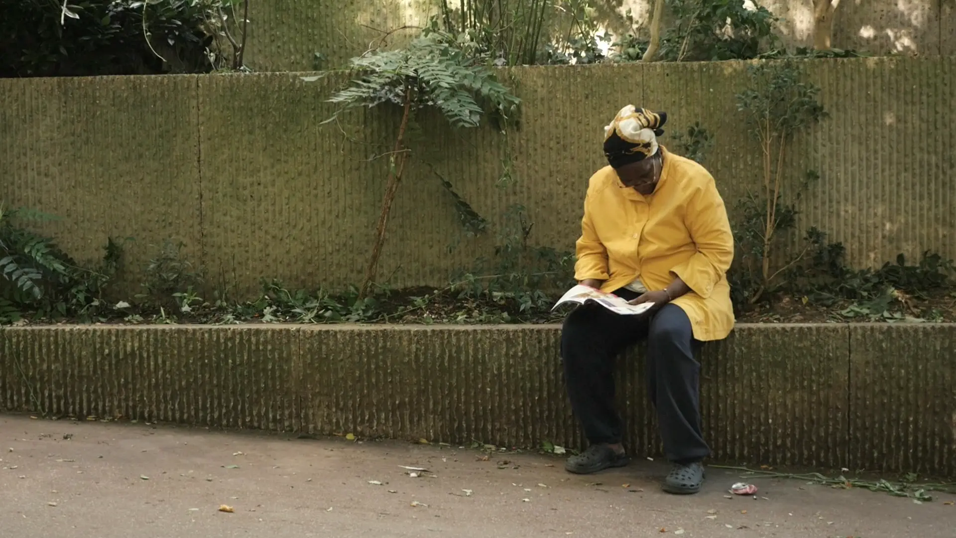Une femme lit. Place Marcel Achard, Belleville, Paris 19e.